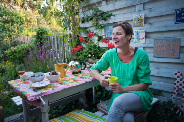 Een persoon zit aan tafel in de tuin.